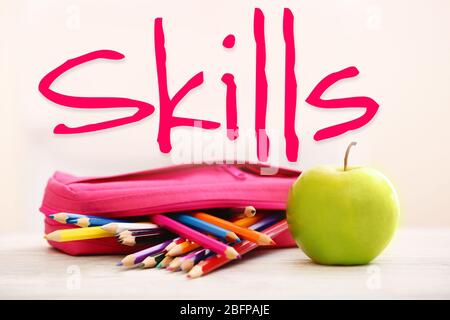 Skills. Apple and pencil-box full of pencils on table in the room Stock Photo