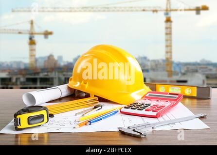 Construction blueprints with tools and helmet on building construction background Stock Photo