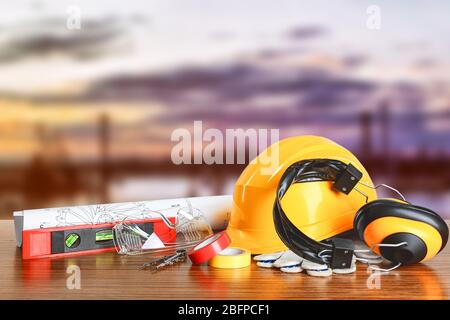 Construction blueprints with tools and helmet on sky background Stock Photo