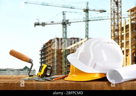 Construction blueprints with tools and helmets on building construction background Stock Photo