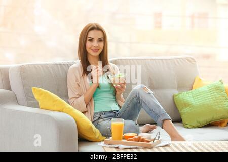 Beautiful young woman having breakfast at home Stock Photo