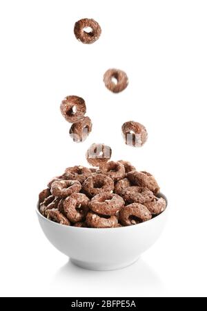 Corn rings falling into bowl on white background Stock Photo