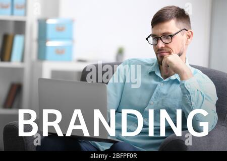 Brand marketing concept. Word BRANDING and man working with laptop on background Stock Photo