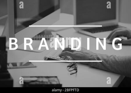 Brand marketing concept. Word BRANDING and man working with computer on background Stock Photo