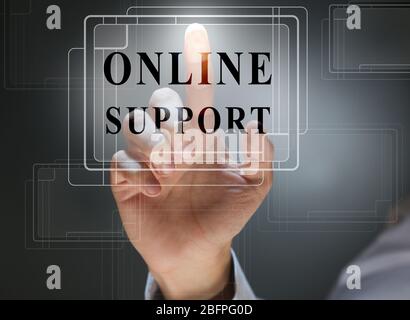 Online support concept. Man pointing on text against dark background, closeup Stock Photo