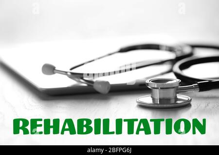 Rehabilitation concept. Tablet and stethoscope on wooden table Stock Photo