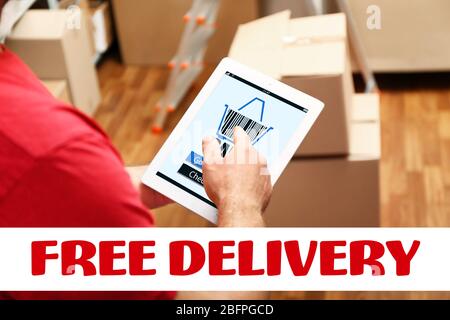 Delivery concept. Courier using tablet at warehouse Stock Photo