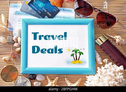 Frame with text TRAVEL DEALS and stuff on bamboo background. Concept of tourism Stock Photo