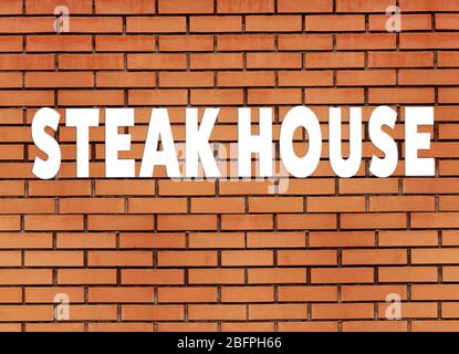 Text STEAK HOUSE on brick wall background Stock Photo