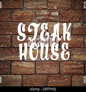 Text STEAK HOUSE on brick wall background Stock Photo