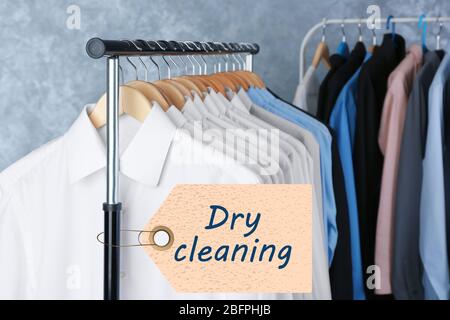 Administrator at dry cleaners keeps clean clothes on hangers in bag, Stock  image