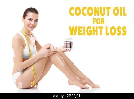 Young woman holding glass jar on white background. Coconut oil for weight loss Stock Photo