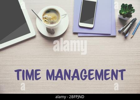 Time management concept. Cup of drink and office tools on wooden background Stock Photo