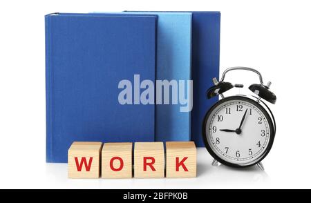 Wooden cubes with word WORK, alarm clock and books on white background. Business concept Stock Photo