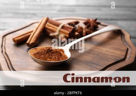 Spoon with cinnamon powder and sticks on wooden background Stock Photo