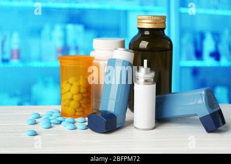 Concept of health care and asthma. Medicines and inhaler on counter at pharmacy Stock Photo