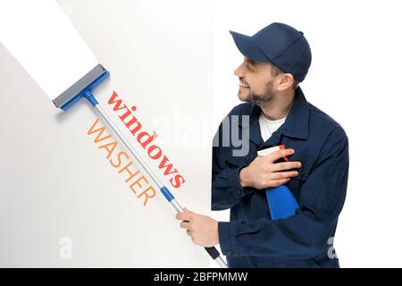 Young window cleaner with squeegee and poster on white background Stock Photo