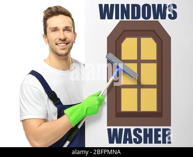 Young window cleaner with squeegee and poster on white background Stock Photo