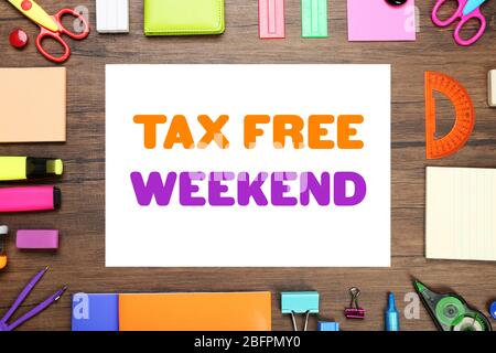 Office supplies and paper with text TAX FREE WEEKEND on wooden background Stock Photo