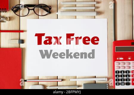 Office supplies and paper with text TAX FREE WEEKEND on wooden background Stock Photo