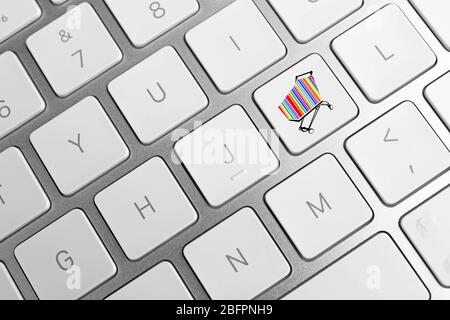 Internet shopping concept. Button with icon of market trolley on keyboard, closeup Stock Photo
