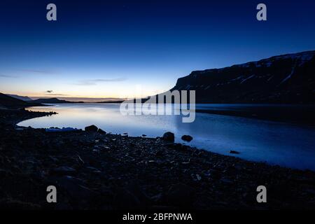 The Hvalfjördur fjord in South West Iceland at dusk with deep blue sky in winter Stock Photo