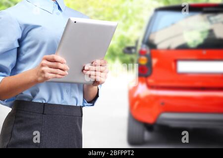 Insurance agent holding tablet and car on background Stock Photo