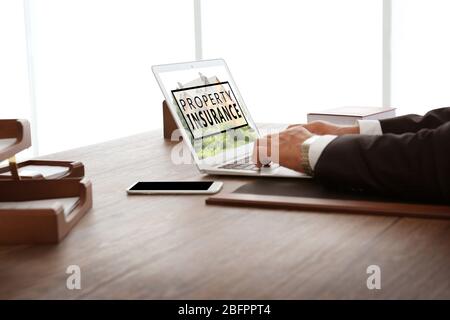 Man using laptop in office. Property insurance concept Stock Photo