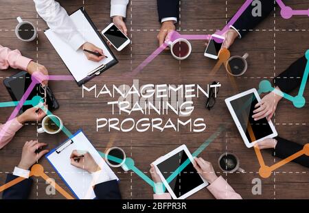 Concept of management training programs. People working with gadgets at table Stock Photo
