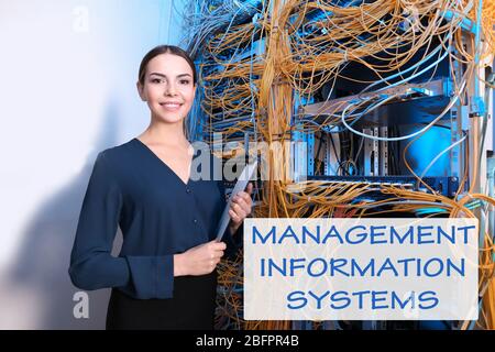 Concept of management information systems. Young engineer with clipboard in server room Stock Photo