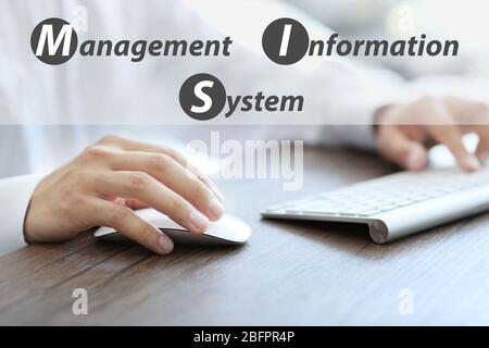 Concept of management information system. Businessman working with computer at wooden table, closeup Stock Photo