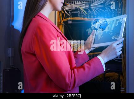 Concept of management information systems. Young engineer with tablet in server room Stock Photo