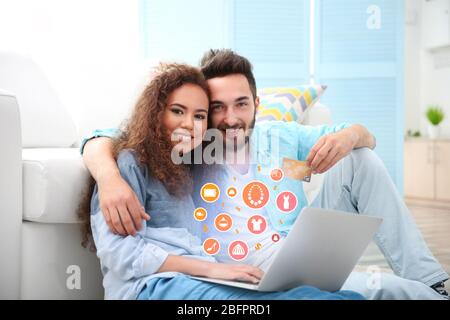 Young couple using laptop for browsing internet store at home. Online shopping concept Stock Photo
