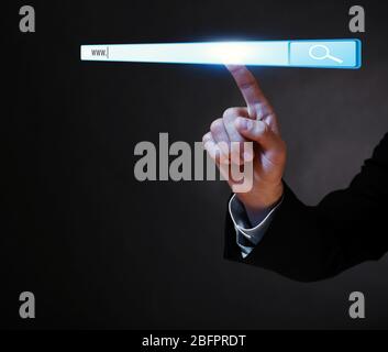 Internet shopping concept. Man clicking on browser search bar, dark background Stock Photo