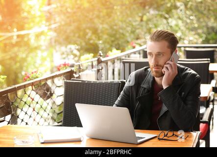 Man with smartphone and laptop at cafe. Internet shopping concept Stock Photo