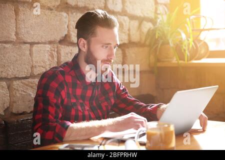 Man using laptop for browsing internet store at cafe. Online shopping concept Stock Photo