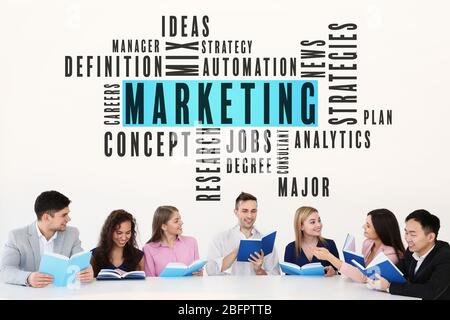 MARKETING word cloud and people with books on light background Stock Photo