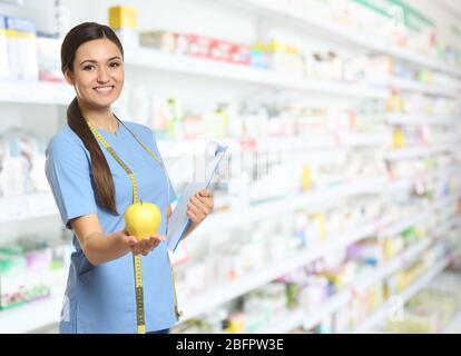 Nutritionist with fruit and clipboard at pharmacy Stock Photo