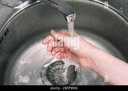 Man washes his hands under running water. Hand under the tap with soapy water. Personal hygiene and prevention of coronavirus Stock Photo