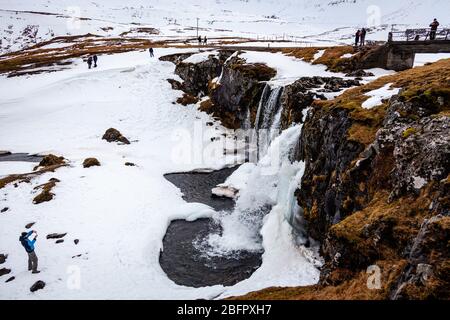 Frozen Kirkjufellsfoss waterfall in south west Iceland on a snowy day in winter Stock Photo