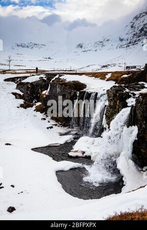 Frozen Kirkjufellsfoss waterfall in south west Iceland on a snowy day in winter Stock Photo