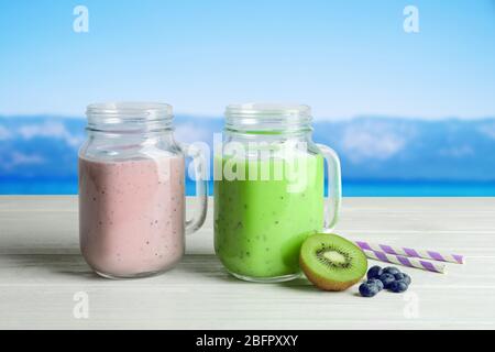 Jars of different protein shakes and landscape on background Stock Photo