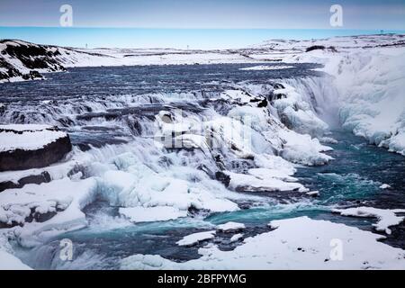 Looking down on the two tier frozen waterfalls at Gullfoss on the Golden Circle tour in Iceland in snow in winter Stock Photo