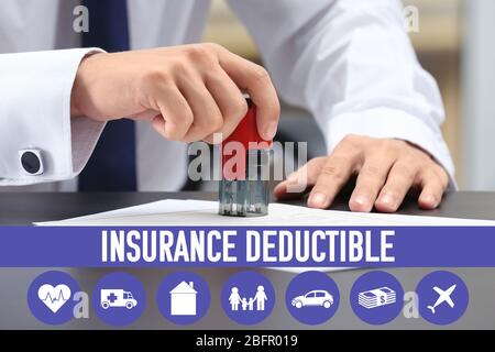 Notary public stamping document at table in office. Concept of insurance deductible Stock Photo