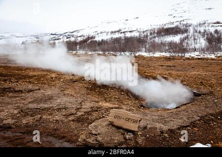 The hot spring Little Geysir or Litli Geysir in Geysir geothermal area, Iceland on a cold snowy day in winter Stock Photo