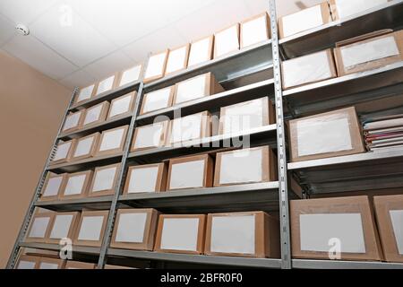 Cardboard boxes with documents on shelving unit in archive Stock Photo