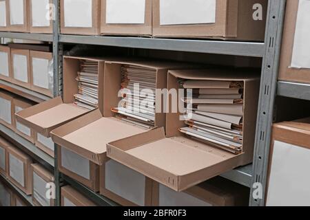 Cardboard boxes with documents on shelving unit in archive Stock Photo