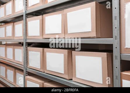 Cardboard boxes with documents on shelving unit in archive Stock Photo