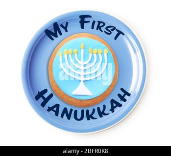 Plate with tasty glazed cookie and text MY FIRST HANUKKAH on white background Stock Photo