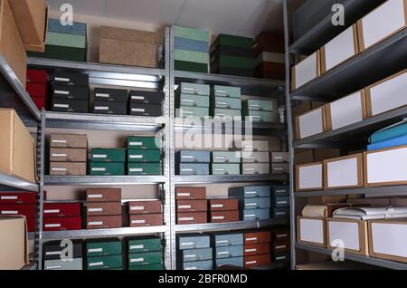 Cardboard boxes with documents on shelving units in archive Stock Photo